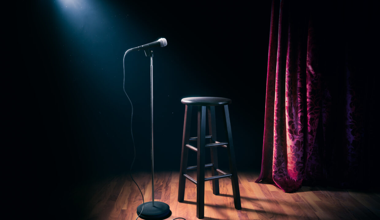 microphone and wooden stool on a stand up comedy stage with refl